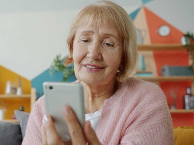 Pessoa afastando o celular do rosto para conseguir ler a tela