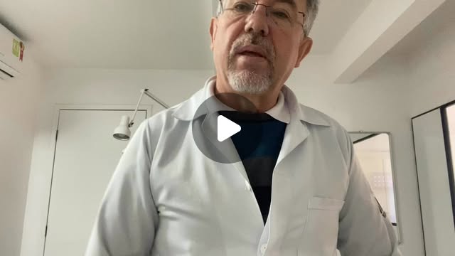 Celso Nunes de jaleco branco falando com a câmera no consultório